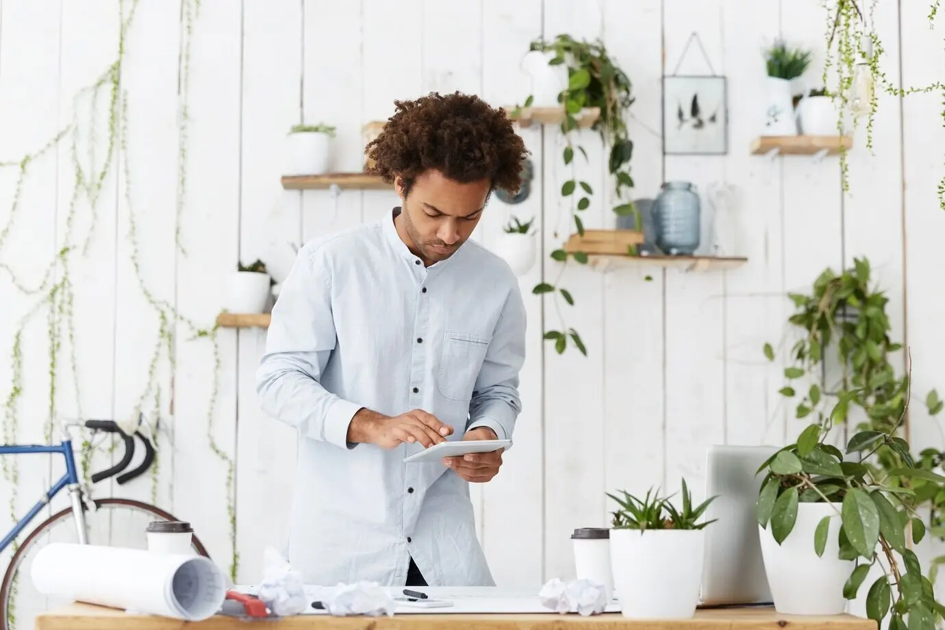 Ernst wirkender afroamerikanischer Ingenieur, Designer oder Architekt mit ausgefallener Frisur, der vor einem Büro steht.