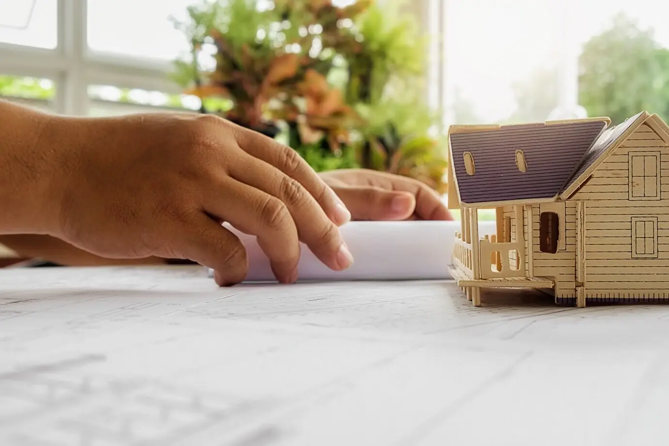 Hände eines Ingenieurs bei der Arbeit an einem Bauplan; Baukonzept. Ingenieurwerkzeuge. Vintage-Look mit Retro-Filtereffekt, weicher Fokus (selektiver Fokus).